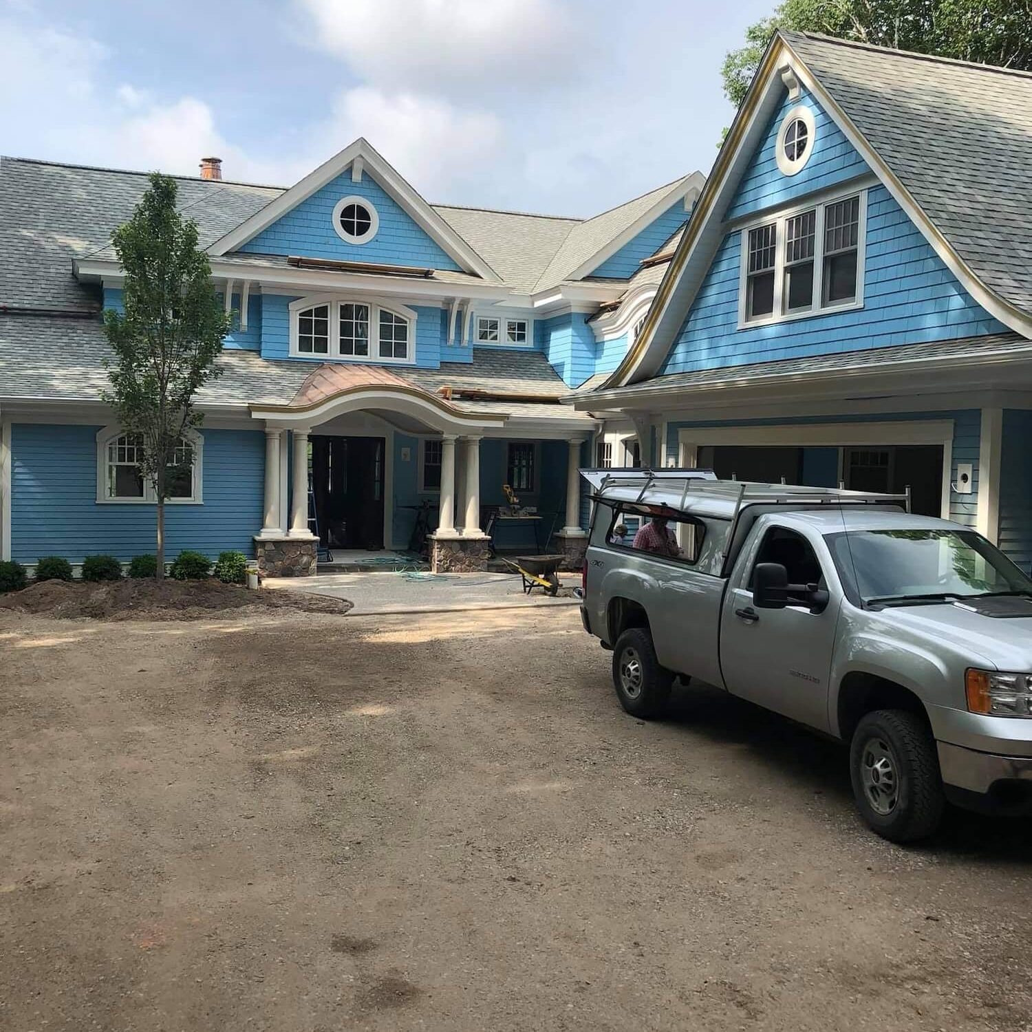 all in one paint & stain work truck outside of exterior painting project in Charlevoix showing a professionally painted home